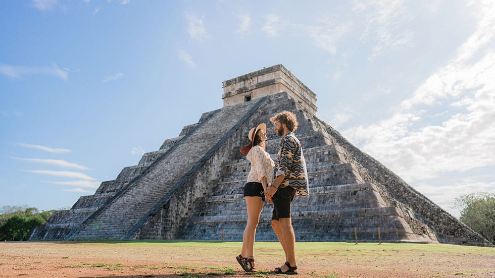 Young couple at Chichen Itza pyramid in Mexico