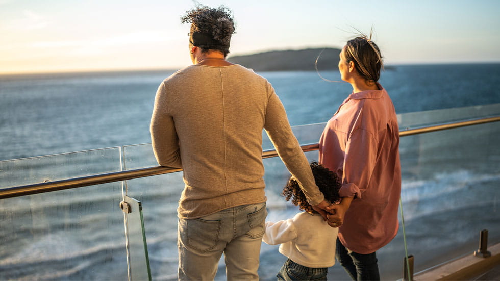 family on cruise ship, looking out at ocean
