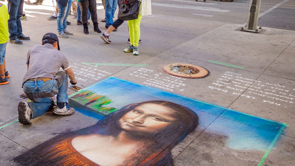 street artist drawing the Mona Lisa with chalk