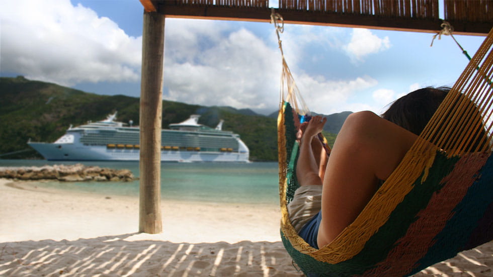 girl relaxing on hammock looking out at cruise ship