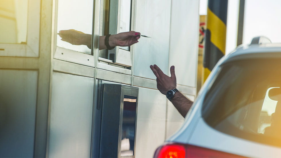 Person paying at highway toll booth