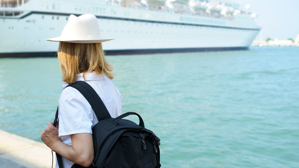 girl looking at cruise ship from dock