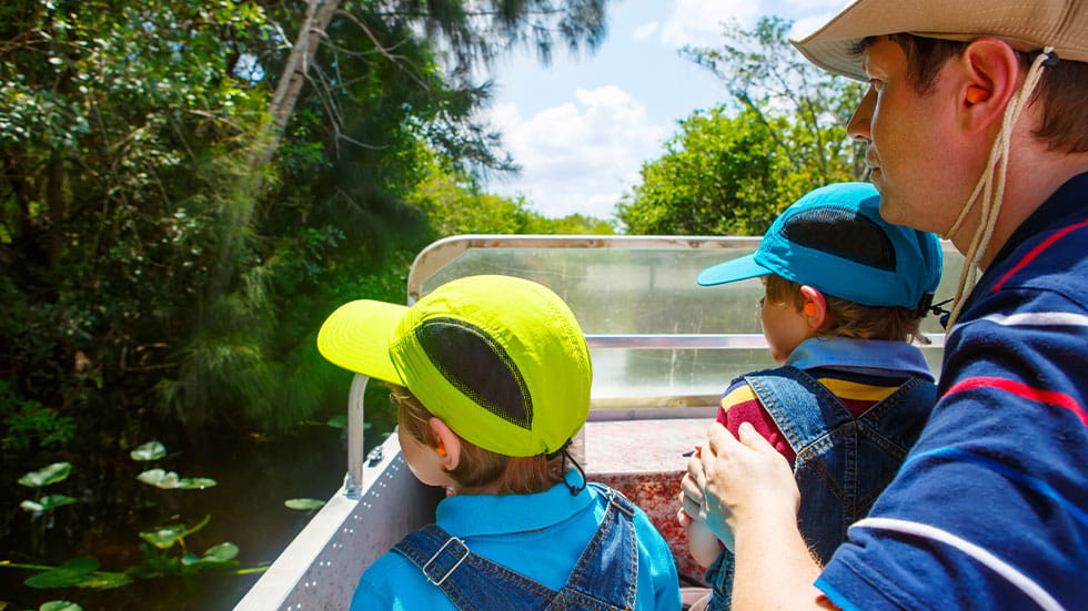 Man and two boys on a boat in Everglades National Park in Miami, FL