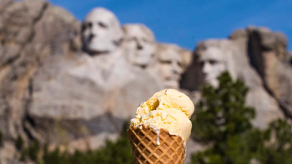 TJ's Vanilla (Thomas Jefferson) ice cream in front of his carving at Mount Rushmore Memorial, South Dakota_credit Travel South Dakota