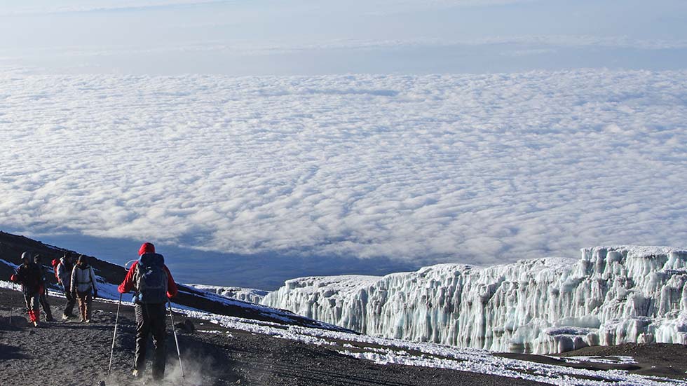 People walk at the top of the kilimanjaro in Tanzania above the clouds