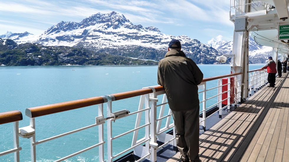 Man standing next to cruise ship railing