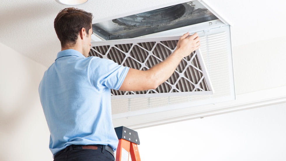 Man changing filter in air conditioner