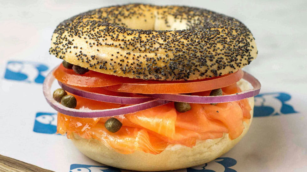 Russ Daughters Poppy seed bagel sandwich with smoked salmon cream cheese tomato onion and caper san