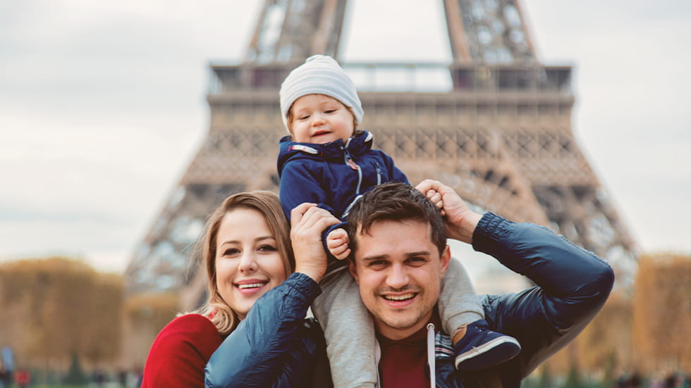 Couple and child in front of the Eiffle Tower in Paris, France