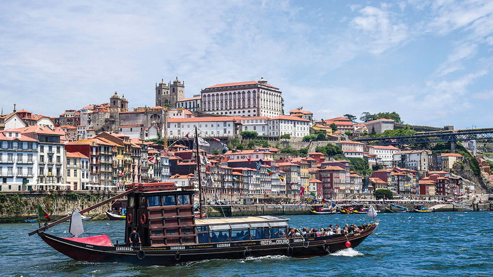 A traditional Portuguese boat (rabelo) plies the Douro River in Porto. Photo by Kerrick James