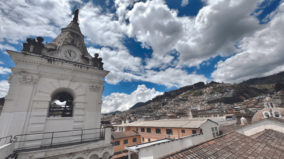looking above the rooftops of old town Quito to a hillside on the edges of the city
