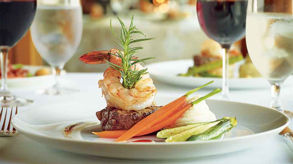 Shrimp and steak dinner on a table with wine