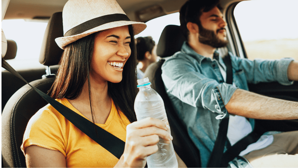 woman drinking water in car