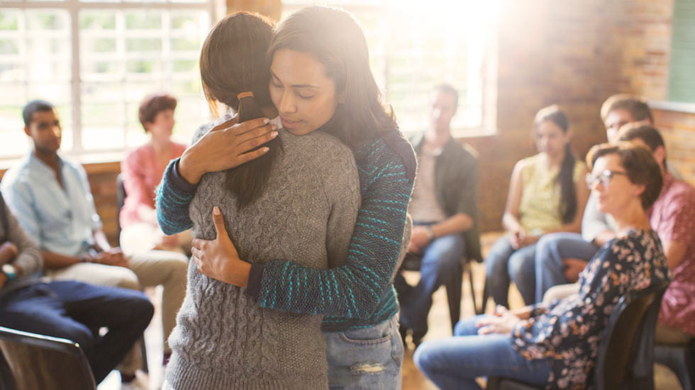 Women hugging at support group