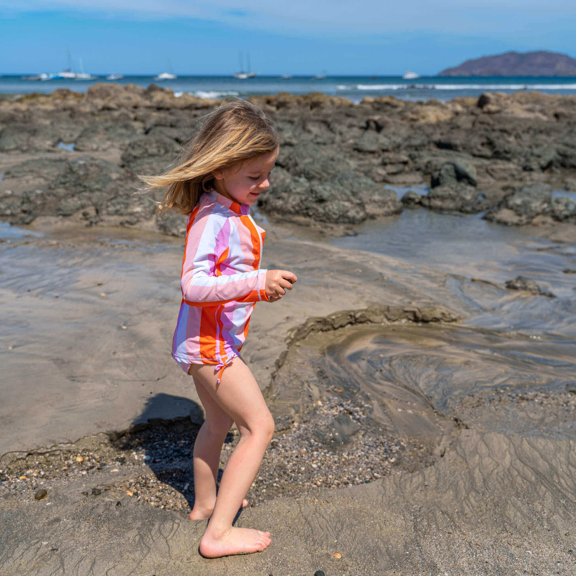 Young girl plays in tide pool