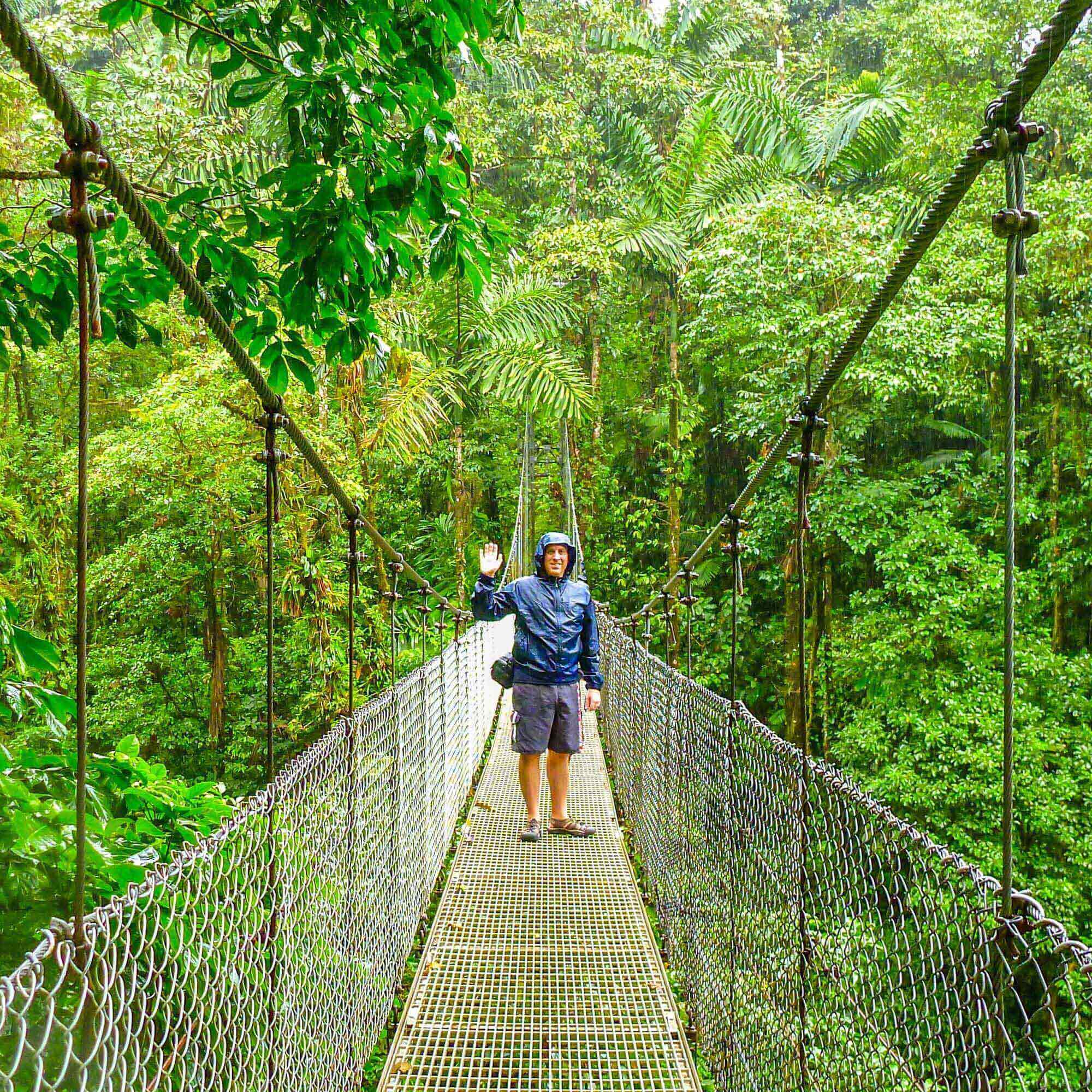 Man standing on a rope bridge in the rainforest