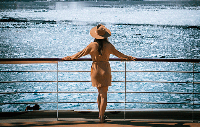 Woman on deck of Cunard ship looking at Alaska scenery